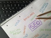 Close-up of notebook with SEO terms and keywords, highlighting digital marketing strategy.
